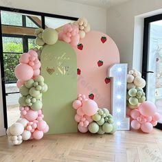 the balloon arch is decorated with strawberry balloons