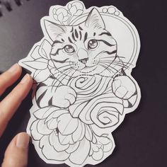 a hand holding a sticker with a cat on it's face and flowers