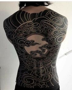 the back of a man's body covered in black and white ink with clouds