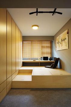 an empty room with wooden cabinets and benches on the floor in front of a window