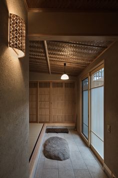 an empty room with some lights on the ceiling and a large rock in the middle