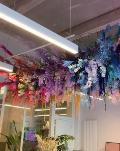 an office decorated with flowers and feathers hanging from the ceiling