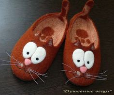 a pair of brown slippers with white eyes and nose painted to look like a cat