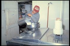 a man pouring something into a metal bowl