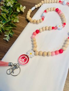 Peace☮️Love💕Learn📓 The cutest lanyard for any special teacher in your life! ✺ Beaded Lanyard, Teacher Lanyard, Wood Bead Lanyard ✺ Bead Size - 12mm  ✺ Lanyard length approx.  ✺ All items are made in a smoke-free home ✺ Secured with a breakaway clasp for connivence and safety!  ✺ Ships throughout the USA from Georgia! ✺ Processing & Shipping: Please allow 3 days for production, although I will try my best to have it be much sooner. USPS estimates you will receive it in 3-5 business days (U.S.) Diy Beaded Lanyards, Wood Bead Lanyard, Teacher Lanyard Beaded, Bead Lanyard, Lanyard Teacher, Cute Lanyards, Silicone Lanyard, Lanyard Necklace, Beaded Lanyard