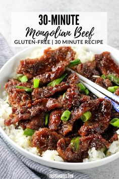 a bowl full of meat and rice with chopsticks in it, on top of a blue towel