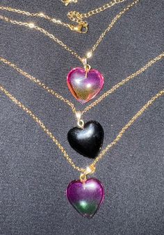 These beautiful glass pendants come in solid black heart, gradient pink yellow heart (see through) and purple green heart (see through).  An 18k gold plated stainless steel chain completes the look.  The glass heart necklace is great for any occasion and gift giving.   It will make a unique addition to anyone's jewelry collection. Product info: *Glass heart pendant is ~2 cm x ~2 cm *18k gold plated stainless steel link cable chain necklace fully extended is ~18 inches *Hypoallergenic and good for sensitive skin *Sold as glass heart pendant and chain necklace together *Color variation and shade can be expected in glass beads. *Please be aware that colors and brightness can vary slightly on different various screening devices. Shipping info: *Ready to ship *All packages shipped via USPS with Trendy Purple Necklace For Gift, Trendy Purple Necklace For Gifts, Trendy Heart Print Necklace For Valentine's Day, Trendy Resin Jewelry For Valentine's Day, Trendy Heart Cut Jewelry Gift, Trendy Multicolor Heart-shaped Jewelry, Trendy Heart Cut Jewelry For Gifts, Purple Heart-shaped Jewelry For Party, Heart Shaped Purple Jewelry For Party