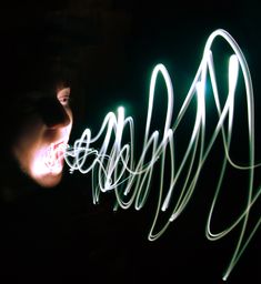 a blurry photo of a person's face in the dark with light streaks