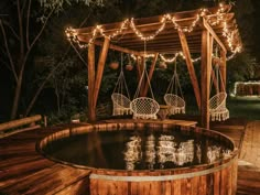 an outdoor hot tub with chairs and lights around it