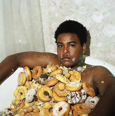 a man is covered in doughnuts and sprinkled with powdered sugar