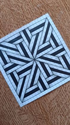 a piece of paper that is on top of a wooden table with black and white designs