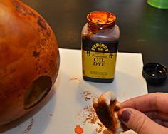 a person is peeling something off of a pumpkin with a knife and some condiments on the table