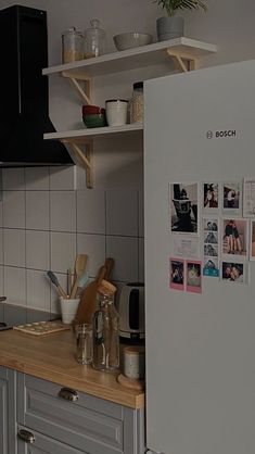 there is a refrigerator in the kitchen with pictures on it and magnets on the door