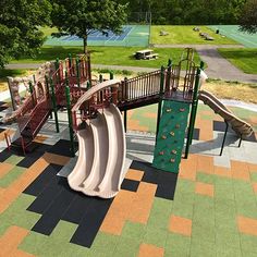 an aerial view of a children's play area with slides and climbing equipment in the foreground