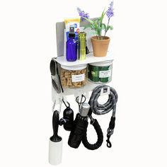 a white shelf with various items on it and a black hose attached to the top