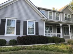 a gray house with white trim and black shutters