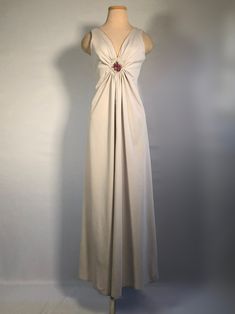 "1970s Sleeveless maxi dress with elegant deep V neckline, gathers at the bust decorated with a diamond of lace and needlepoint upon a lovely simple maxi dress. This dress is in great shape, no snags, holes or stains. Bust 36\", waist 30\", hips 50\", empire waist 11\" front and 13\" back, lenght 53\"," Elegant Lined Maxi Dress For Dinner, Vintage V-neck Evening Maxi Dress, Elegant Beige Empire Waist Maxi Dress, Vintage Beige V-neck Maxi Dress, Elegant Beige Maxi Dress With Empire Waist, Vintage V-neck Maxi Dress For Wedding, Vintage V-neck Maxi Dress For Formal Occasions, Vintage Floor-length Maxi Dress For Formal Occasions, Formal Beige V-neck Evening Dress