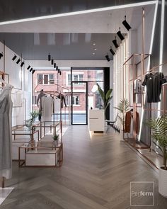 an empty store with clothes on racks and plants in vases next to the doors