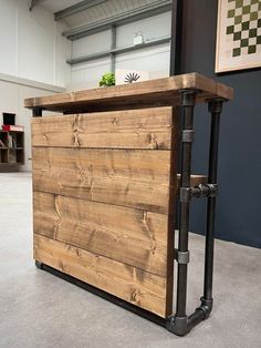 a large wooden box with pipes on the side and a potted plant in it