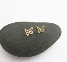 "14k gold butterfly stud earrings. Pretty and dainty earrings, handmade of solid 14k gold. I cut each butterfly with a jeweler's saw, from a solid gold sheet, file it, and solder a 14k gold post to the back of each one. I give the small butterflies a shiny mirror-like finish. You can choose between a few options: A cute mismatched pair - one butterfly flat and the other is with raised wings. A pair of flat earrings. Or pair with raised wings. Butterflies symbolize hope, transformation, rebirth a Minimalist Butterfly Earrings For Everyday Wear, Gold Butterfly Earrings For Gift, Minimalist Butterfly Earrings For Everyday, Minimalist Butterfly Charm Earrings For Gift, Minimalist Butterfly Charm Earrings Gift, Gold Minimalist Earrings With Butterfly Charm, Small Butterfly Earrings Gold, Minimalist Gold Earrings With Butterfly Charm, 14k Gold Butterfly Earrings For Gift