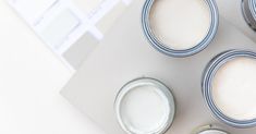 four cans of white paint sitting on top of a table