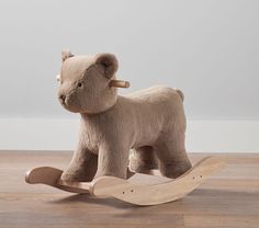 a wooden rocking toy with a bear on it