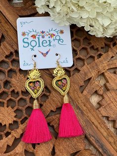 Infuse your style with a dash of Mexican charm with our hand-painted heart earrings. Each pair is meticulously crafted by skilled artisans, capturing the essence of Mexico's rich culture and artistic heritage.  Every piece is completely unique because of the detailed process that goes into creating it. The black lacquer is created by mixing in layers of dirt with a grease from the Cochinilla bug. The flowers are painted on with our finger tips using ground up natural pigments and linseed oil. To Nickel-free Dangle Heart Earrings For Festivals, Adjustable Tassel Jewelry For Festivals, Bohemian Drop Heart Earrings For Gift, Bohemian Style Heart Drop Earrings For Gift, Festival Gift Jewelry With Tassels, Artsy Pink Jewelry For Festivals, Pink Artsy Jewelry For Festivals, Nickel-free Heart Earrings For Festivals, Nickel Free Heart Earrings For Festivals