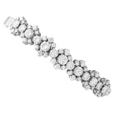 A stunning, fine and impressive 7.15 carat diamond and 18 karat white gold bracelet; part of our diverse collection of vintage diamond bracelets. This stunning, fine and impressive vintage diamond bracelet has been crafted in 18k white gold. The articulated anterior portion of the bracelet is ornamented with seven pierced decorated floriated cluster designs, each embellished with an impressive central feature claw set transitional modern brilliant round cut diamond. Each central diamond is encom Vintage White Gold Diamond Bracelet, Luxury Vintage White Gold Bracelet, Luxury Vintage Diamond Bracelet Gift, Luxury Vintage Rose Cut Diamond Bracelets, Luxury Vintage Brilliant Cut Bracelet, Luxury Vintage Diamond Cut Bracelet, Vintage Diamond Bracelet, White Gold Diamond Bracelet, White Gold Bracelet