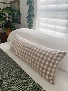 a bed with a checkered pillow sitting on top of it