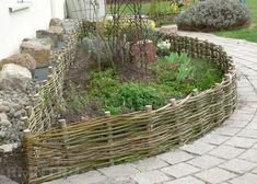 a garden with rocks, grass and plants in the middle is shown on a brick walkway