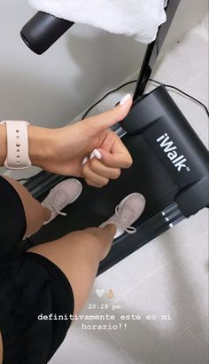 a woman sitting on top of a chair with her foot in the air while holding onto an electronic device