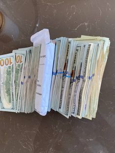 several stacks of money sitting next to each other on top of a counter in front of a faucet