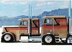 two large trucks parked next to each other in front of some mountains and blue sky