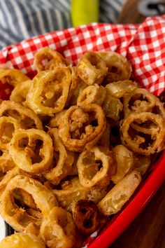 a red basket filled with onion rings on top of a table