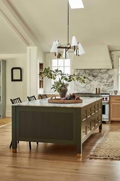 a large kitchen with an island in the middle and lots of counter space on one side