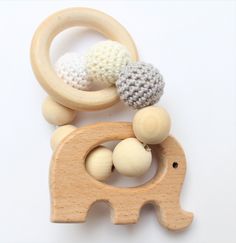 a wooden toy elephant with two balls on it's back and a crocheted ring around its neck