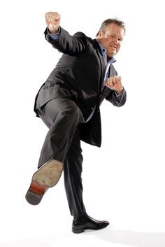 a man in a suit and tie is running with his foot on the ground while wearing shoes