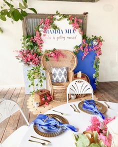 the table is set up with flowers and place settings for guests to sit down at