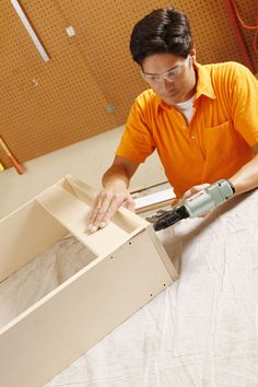 a man in an orange shirt working on a box