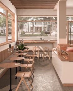 an empty restaurant with tables and chairs in front of large windows that look out onto the street