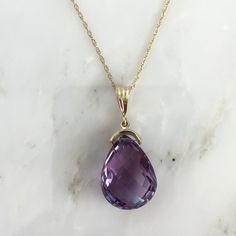 Details: Lovely vintage amethyst pendant and 14K gold necklace. The amethyst is faceted, and has an amazing sparkle glow. The amethyst measures 15.19 x 19.67 x 10.37mm, and is roughly 14.5 carats. This pendant is sold with a 14K gold chain, and the chain is modern. Please ask all necessary questions prior to placing an order! Size: The chain measures 16 inches, and the pendant is 1 1/4 inches. Condition: The overall all condition of this piece is very good. Classic Amethyst Purple Necklace, Purple Drop Necklace For Formal Occasions, Classic Purple Amethyst Necklace, Formal Purple 14k Gold Necklace, Formal Purple Drop Necklace, Classic Amethyst Pendant Necklace, Formal Faceted Amethyst Necklace, Purple 14k Gold Pendant Necklace, Formal Drop Amethyst Necklaces