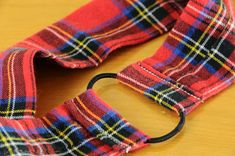 a red and blue plaid tie sitting on top of a wooden table