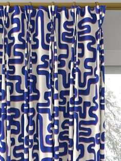 blue and white patterned curtains hanging in front of a window