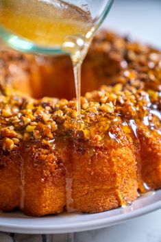 someone is pouring syrup on a bundt cake