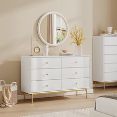 a white dresser sitting next to a bed in a room with beige walls and wooden floors