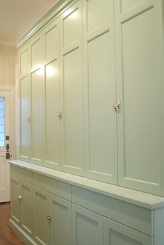 an empty room with white cabinets and wood floors