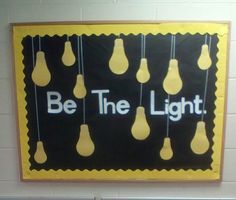 a bulletin board with light bulbs hanging from it's sides and the words be the light