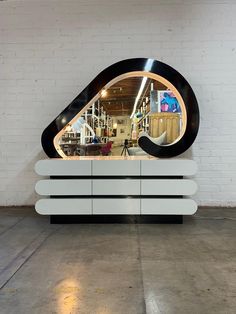 a large mirror sitting on top of a white cabinet next to a wall with bookshelves