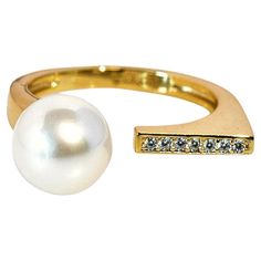 An open ring, plated in 14k gold over sterling silver, boasts a singular white freshwater pearl on one end and a radiant line of diamonds on the other. This design symbolizes the intertwining of two souls, with the pearl embodying purity and the diamonds reflecting everlasting commitment—a testament to enduring love in its simplest, most elegant form. Specifications: - Metal Type: Sterling Silver - Diamonds: Cubic Zirconia - Ring Weight: 3 Grams - Pearl Type: Freshwater Pearl - Pearl Size: 8.5 mm - Pearl Shape: White - Pearl Shade: Round - Pearl Surface: Clean - Pearl Shine: AAA – Excellent - Ring Size adjustable: Yes - Ring Size: Indian size 10 to 20, US size 5 to 9.25 Elevate your style and make a statement with our Designer Open Ring. Discover the perfect blend of classic elegance and c Modern 14k Gold Pearl Open Ring, White Freshwater Pearl, Cubic Zirconia Rings, Pearl Types, Minimalist Rings, Open Ring, Pearl Size, Silver Diamonds, Bridal Rings