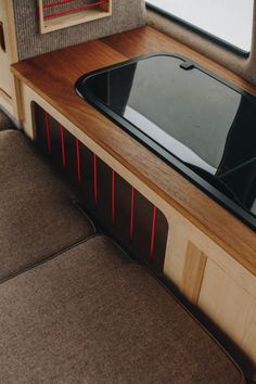 the interior of a camper with wood trimming and black glass in the window